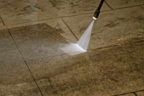 Spraying floor with backpack sprayer
